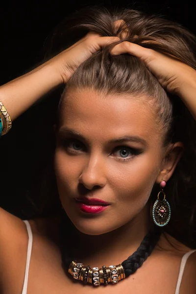 Karanlık bir arka plan üzerinde beyaz elbiseli güzel esmer