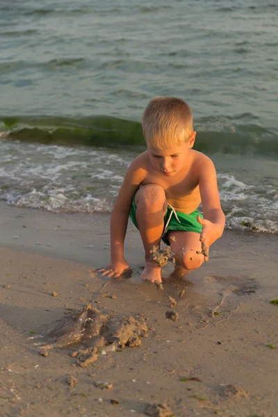 Sahilde kumda oynayan genç bir çocuk
