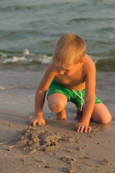 Sahilde kumda oynayan genç bir çocuk