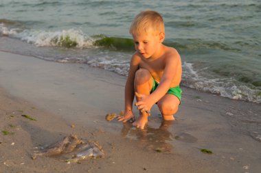 Sahilde kumda oynayan genç bir çocuk