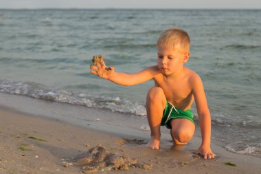 Sahilde kumda oynayan genç bir çocuk