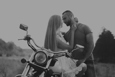 Kaslı adam bir motosiklet orta alan yolun üzerinde güzel bir kadınla