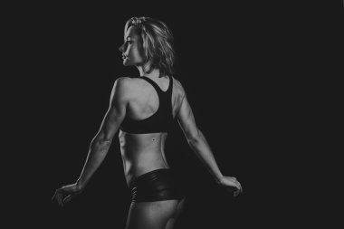 Karanlık bir arka plan üzerinde güzel spor kız