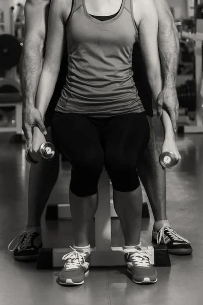 Pareja joven en el gimnasio en el entrenamiento conjunto — Foto de Stock