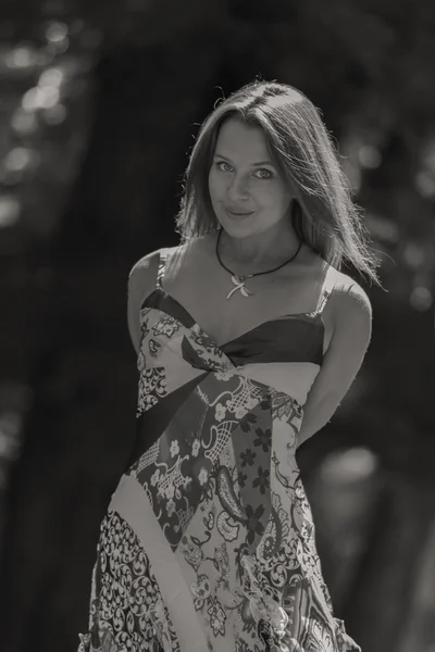 A young and attractive girl in beautiful summer dress middle of sunny meadows — Stock Photo, Image