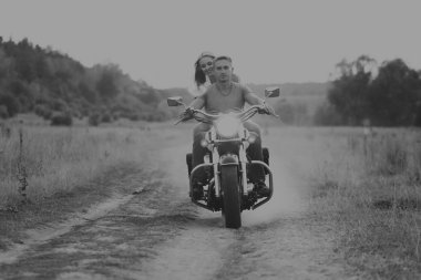 Kaslı adam bir motosiklet orta alan yolun üzerinde güzel bir kadınla