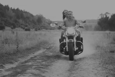 Kaslı adam bir motosiklet orta alan yolun üzerinde güzel bir kadınla