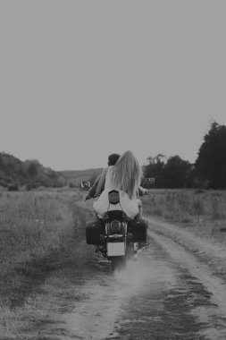 Kaslı adam bir motosiklet orta alan yolun üzerinde güzel bir kadınla