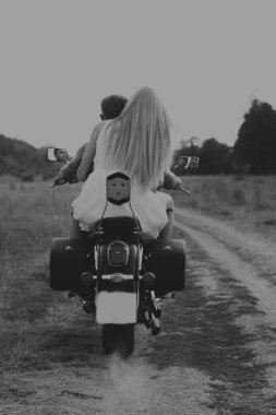 Kaslı adam bir motosiklet orta alan yolun üzerinde güzel bir kadınla