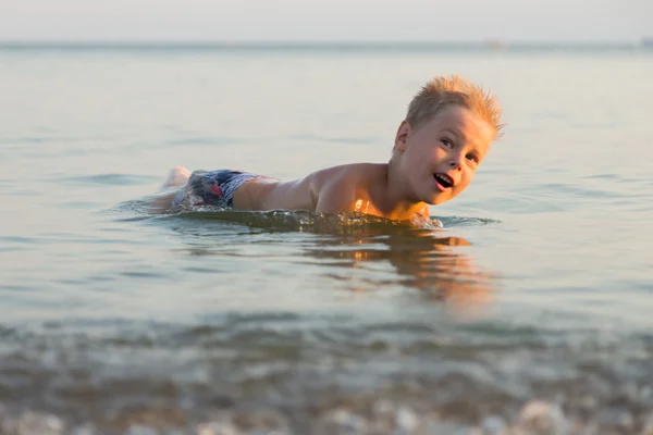 Młody chłopak bawiące się w piasku na plaży — Zdjęcie stockowe