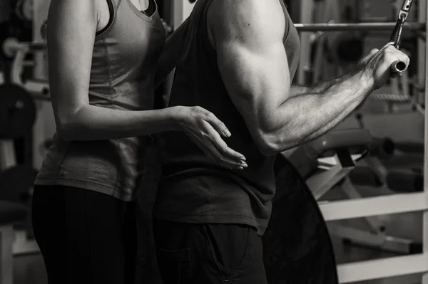 Junges Paar im Fitnessstudio beim gemeinsamen Training — Stockfoto