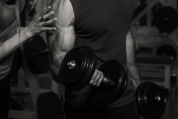 Pareja joven en el gimnasio en el entrenamiento conjunto —  Fotos de Stock