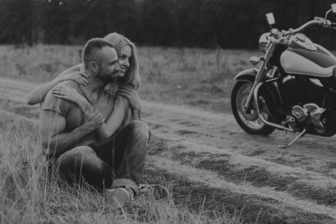 Kaslı adam bir motosiklet orta alan yolun üzerinde güzel bir kadınla