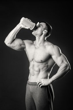 Bir şişe süt karanlık bir arka plan üzerinde vücut geliştirmeci