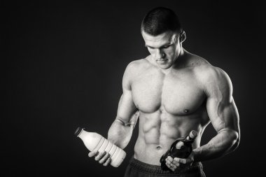 Bir şişe süt karanlık bir arka plan üzerinde vücut geliştirmeci