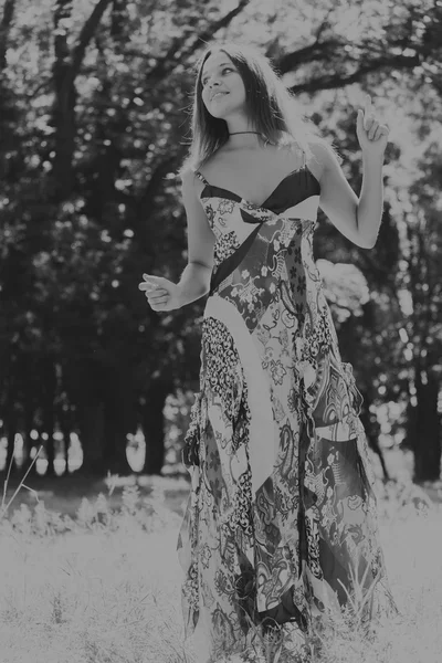 Молодая и привлекательная девушка в красивом летнем платье посреди солнечных лугов — стоковое фото