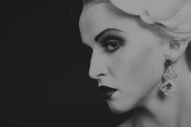 Karanlık bir arka plan üzerinde vintage elbiseli güzel sarışın