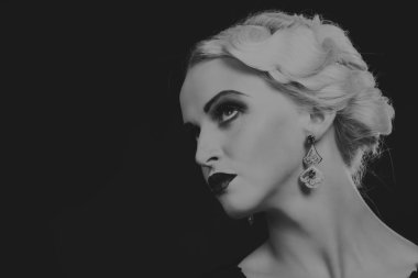 Karanlık bir arka plan üzerinde vintage elbiseli güzel sarışın