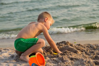 Sahilde kumda oynayan genç bir çocuk