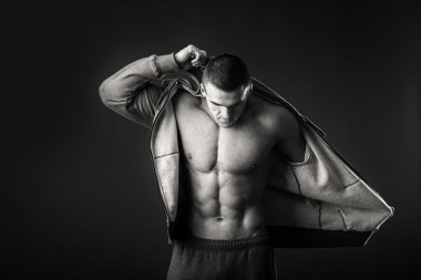 Karanlık bir arka plan üzerinde bir spor ceketli kaslı adamı