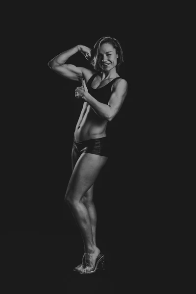 A bela menina de esportes em um fundo escuro — Fotografia de Stock