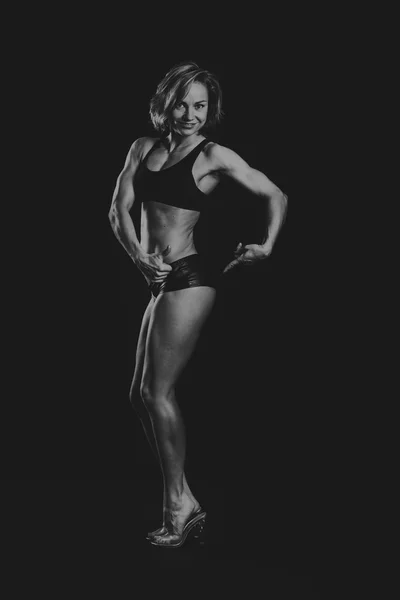 A bela menina de esportes em um fundo escuro — Fotografia de Stock