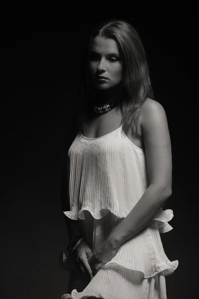 Krásná brunetka v bílých šatech na tmavém pozadí — Stock fotografie