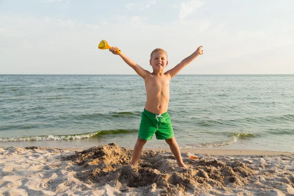 Sahilde kumda oynayan genç bir çocuk