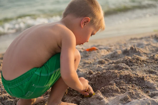 Sahilde kumda oynayan genç bir çocuk