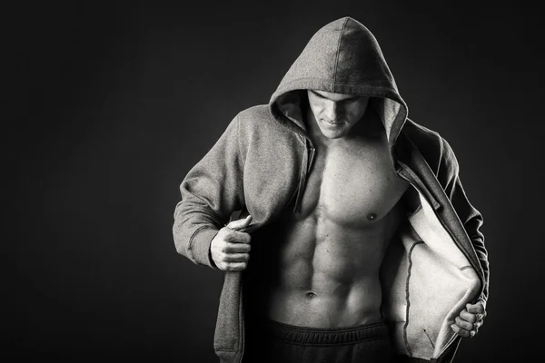 Hombre musculoso en una chaqueta deportiva sobre un fondo oscuro —  Fotos de Stock