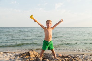 Sahilde kumda oynayan genç bir çocuk