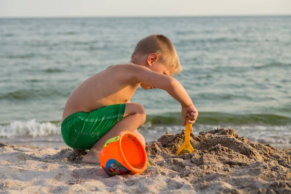 Sahilde kumda oynayan genç bir çocuk