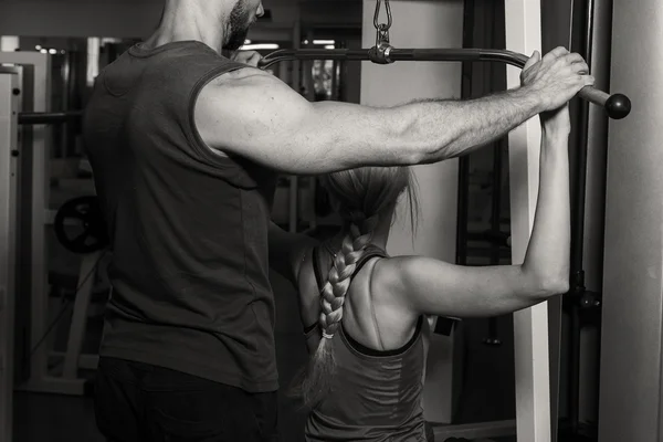 Junges Paar im Fitnessstudio beim gemeinsamen Training — Stockfoto