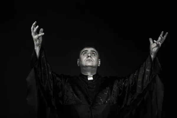 Profesionální divadelní herec v masce kněze na tmavém pozadí — Stock fotografie
