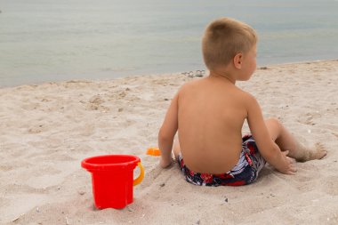 Sahilde kumda oynayan genç bir çocuk