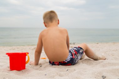 Sahilde kumda oynayan genç bir çocuk