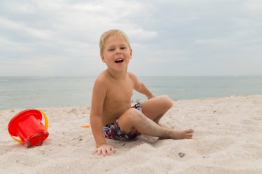 Sahilde kumda oynayan genç bir çocuk