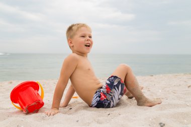 Sahilde kumda oynayan genç bir çocuk