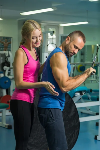 Jong paar in de sportschool bij de gemeenschappelijk opleiding. — Stockfoto