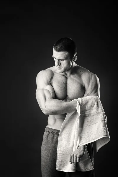 Μυώδης άνδρας με μια πετσέτα στα χέρια του σε σκούρο φόντο — Φωτογραφία Αρχείου