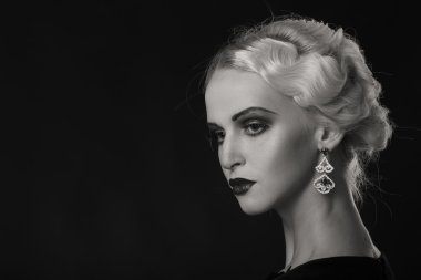 Karanlık bir arka plan üzerinde vintage elbiseli güzel sarışın