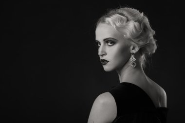 Karanlık bir arka plan üzerinde vintage elbiseli güzel sarışın