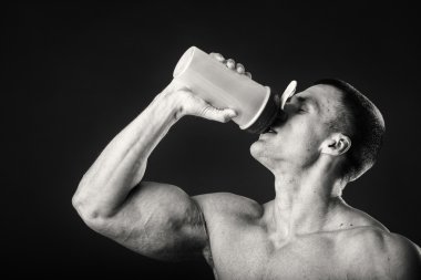 Bir shaker karanlık bir arka plan karşı elinde olan kas adam