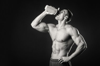 Bir shaker karanlık bir arka plan karşı elinde olan kas adam