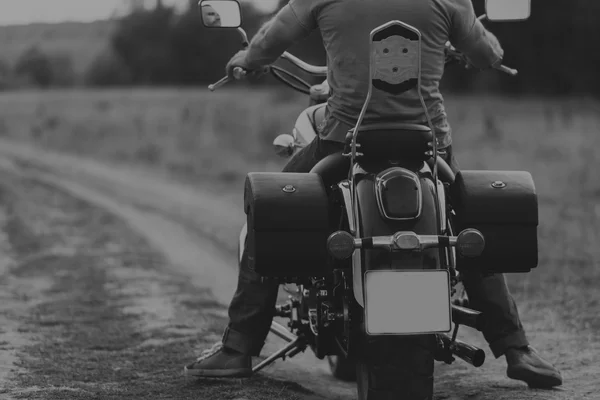 Een man op een motorfiets midden van een veld weg — Stockfoto