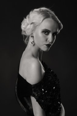 Karanlık bir arka plan üzerinde vintage elbiseli güzel sarışın