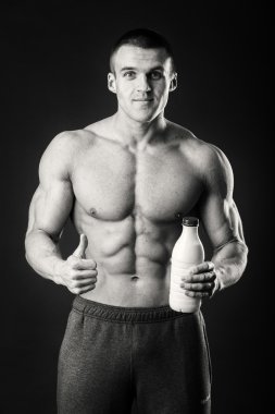 Adam gri arka plan üzerinde poz adam vücut geliştirmeci bir shaker içecekler için tutuyor. Adam bir protein shake, su, amino asitler shaker içme. Spor, spor ve beslenme, Gıda katkı maddesi.