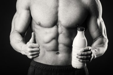 Adam gri arka plan üzerinde poz adam vücut geliştirmeci bir shaker içecekler için tutuyor. Adam bir protein shake, su, amino asitler shaker içme. Spor, spor ve beslenme, Gıda katkı maddesi.
