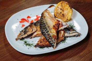 Beyaz bir plaka üzerinde ızgara sebzeli uskumru füme.