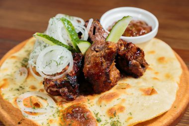 Ahşap bir tablete iştah açıcı Barbekü pişmiş sebze ve sos ile servis.